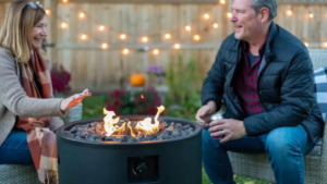 A couple sitting around the firepit enjoying a drink on a cool winters night.